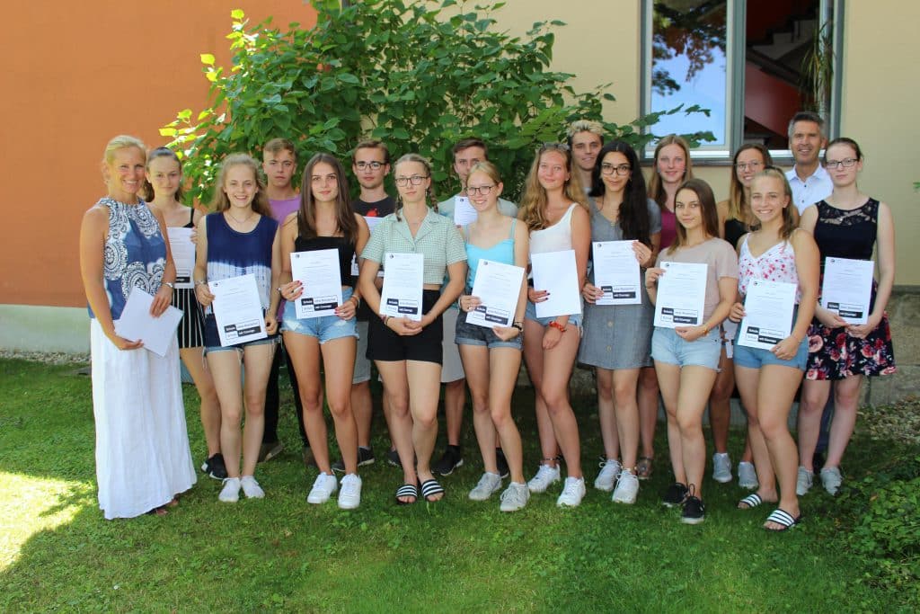 Schülerinnen und Schüler nehmen ihre Zertifikate als Antidiskriminierungstrainer:innen entgegen.